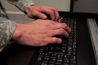 Airman 1st Class Brock Metscher, 28th Communications Squadron cyber systems operations operator, inputs information into a server computer at Ellsworth Air Force Base, S.D.