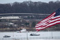 Police and coast guard boats are seen around a wreckage site in the Potomac River